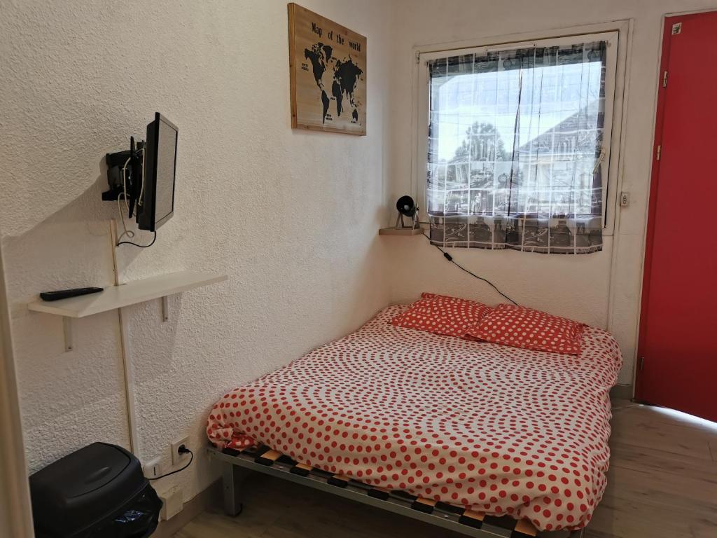 a small bed in a room with a window at Studio meublé équipé calme et bien situé in Chambray-lès-Tours