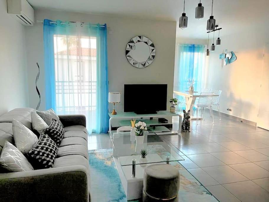 a living room with a couch and a tv at PRADO PLAGE DAVID - MARINA OLYMPIQUE JO 2024 - STADE VELODROME - PARC BORELY - LA CORNICHE- CLUB NAUTIQUE - appartement situé à 800m de JO 2024 et à 10m de plage -Luxury apartment by the Sea in Marseille