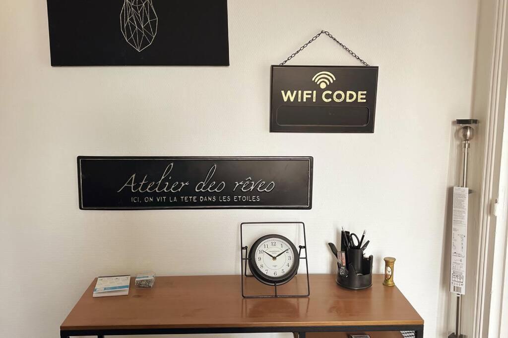 un bureau avec une horloge et une pancarte sur un mur dans l'établissement Peaceful Stay Near Insead and Castle, à Fontainebleau