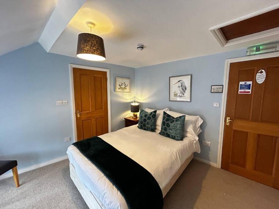 a bedroom with a bed with blue walls at Quail in Lyddington