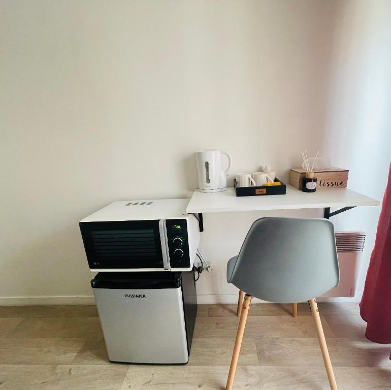 a microwave sitting on top of a counter with a chair at La Chambre in Saint-Denis