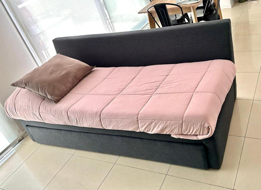 łóżko z różową kołdrą i poduszką w obiekcie Patagonia Suites - Departamentos w mieście Neuquén