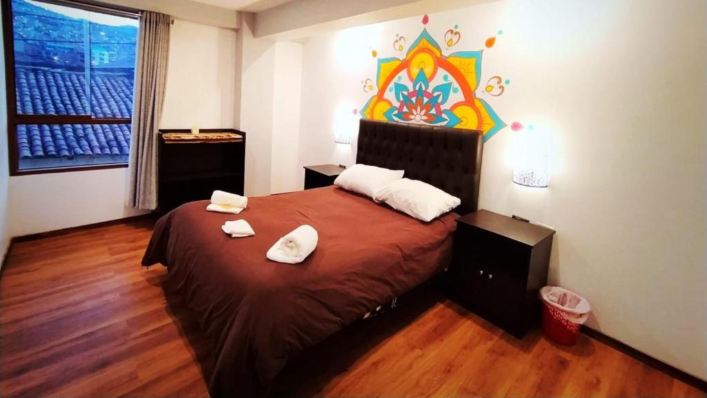 a bedroom with a bed with two white towels on it at Magic Packer Hostel in Cusco