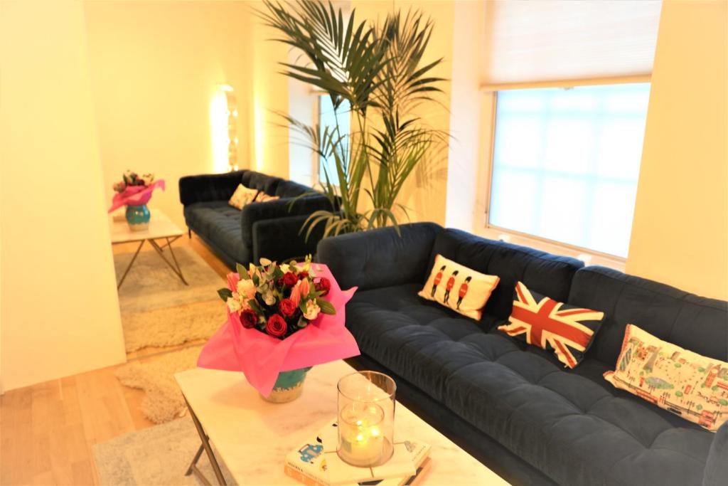 ein Wohnzimmer mit einem schwarzen Sofa und einem Tisch in der Unterkunft Cozy place Soho London in London