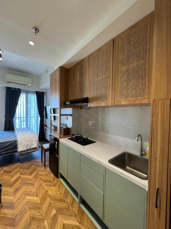 a kitchen with a sink and a bed in a room at Studio Amor Apartemen Pakuwon City Mall BACA DESKRIPSI in Surabaya