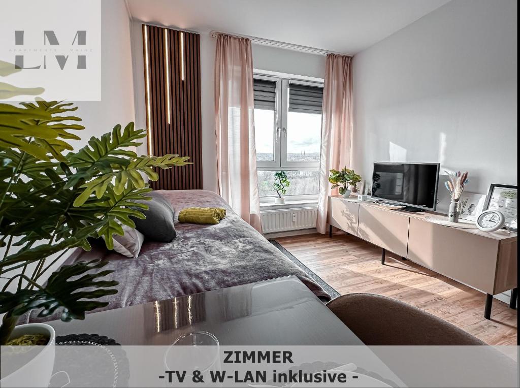 a living room with a bed and a tv in it at LM-ApartmentsMainz-07 in Mainz