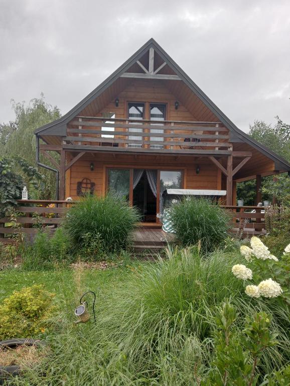 een groot houten huis met een groot balkon bij Drewniana chatka in Budy Stare