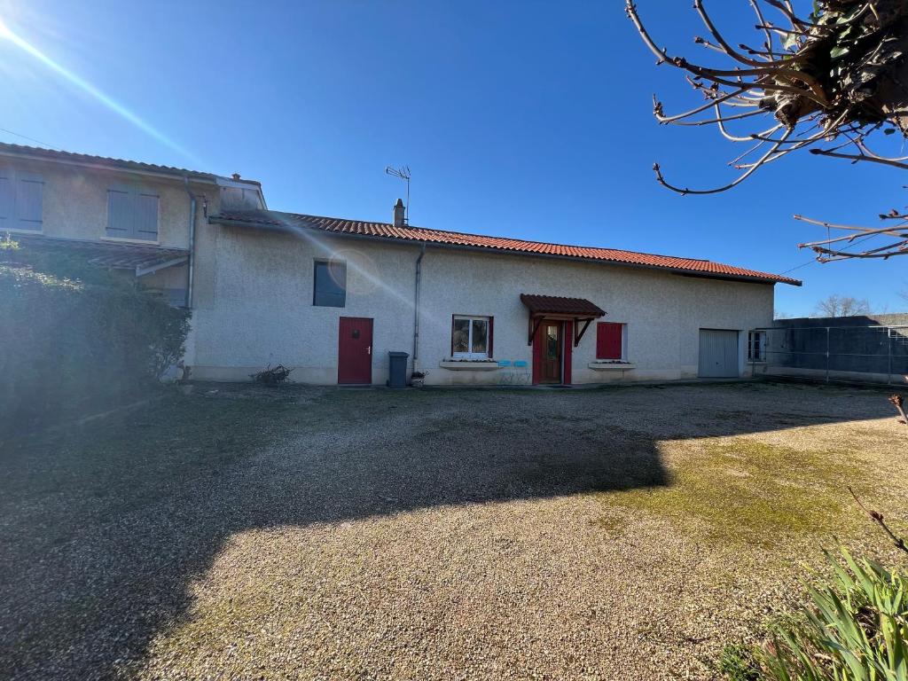 Saint-Jean-de-ThurigneuxにあるChez Paulの赤い扉と庭のある白い家