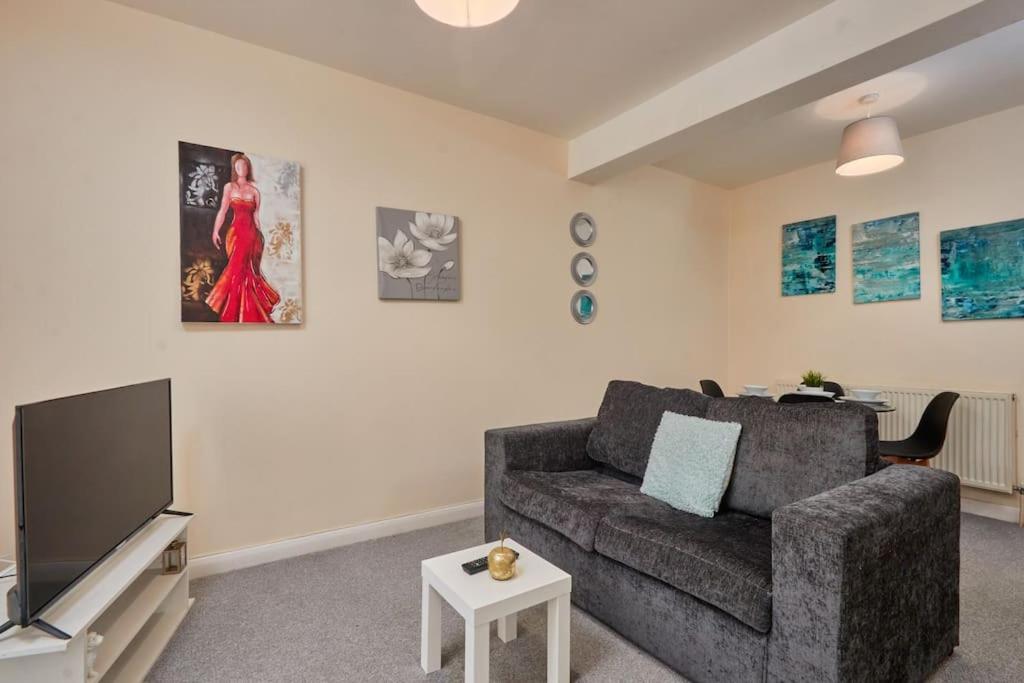 a living room with a couch and a flat screen tv at Comfy Home on Burton Road in Derby