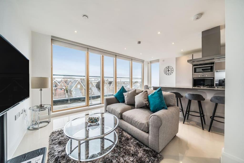 a living room with a couch and a table at Amazing One bedroom Penthouse in Wimbledon in London