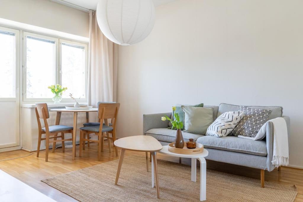 - un salon avec un canapé et une table dans l'établissement 2-Bedroom, Steps from the Metro!, à Helsinki