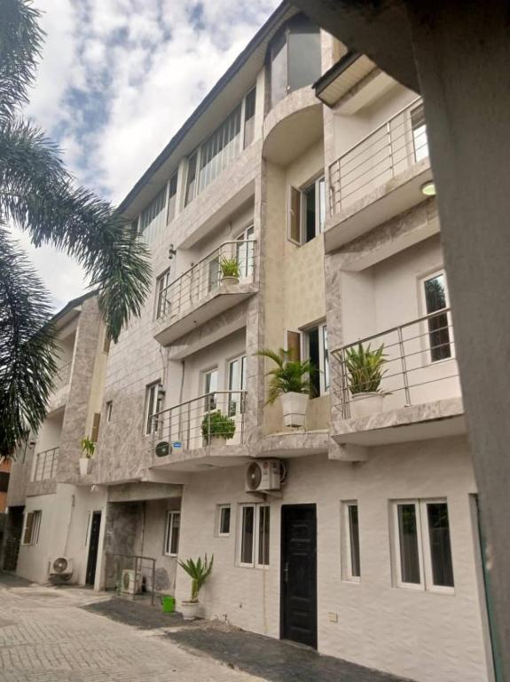 un gran edificio de apartamentos con macetas en los balcones en KINGS AVENUE SERVICE APARTMENTS, en Lagos