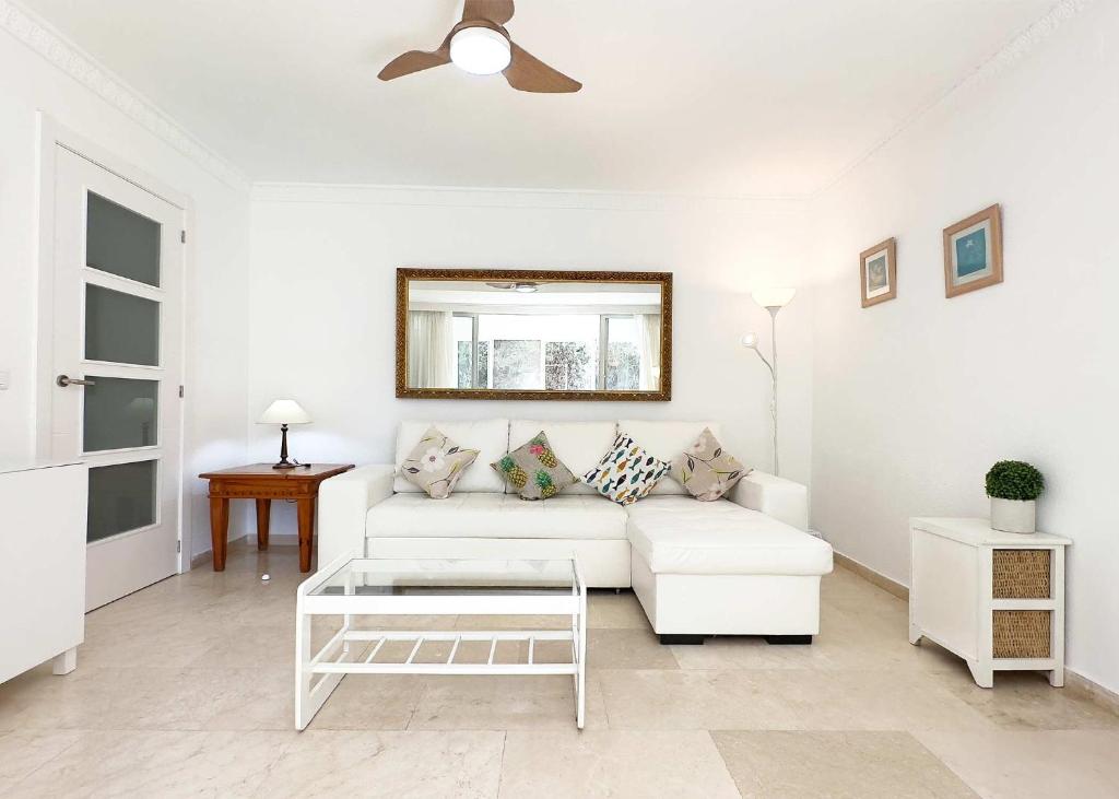 a living room with a white couch and a table at 1 Bedroom Apartment Second Line Beach- Parque Marbella Building in Marbella