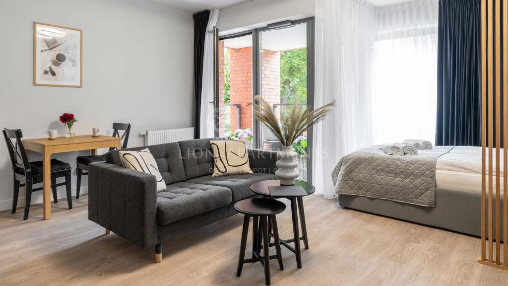 um quarto com um sofá, uma cama e uma mesa em Lion Apartments - SCALA City Center Apartments&Studio IC em Gdansk