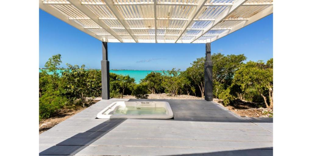 an outdoor pavilion with a hot tub on the beach at NEW Waterside Home Whirlpool Spa Tub Smart TV in Providenciales