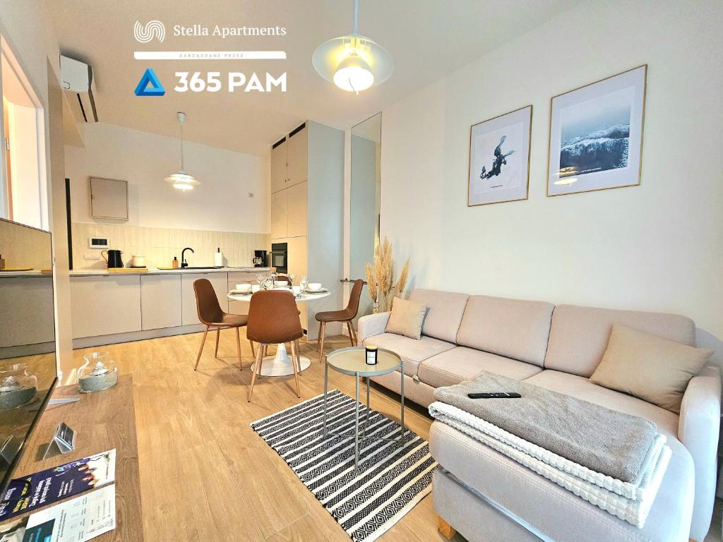 a living room with a couch and a kitchen at 365PAM - Apartament Dobra Aura w Summer Lofts in Ustronie Morskie