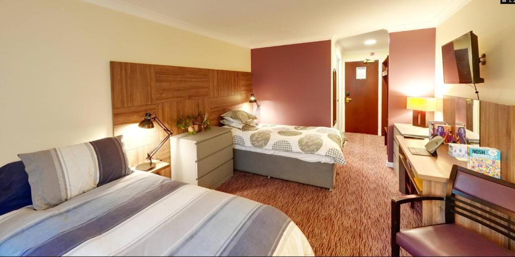 um quarto de hotel com uma cama e uma secretária em The University of Buckingham - Mount Pleasant em Buckinghamshire