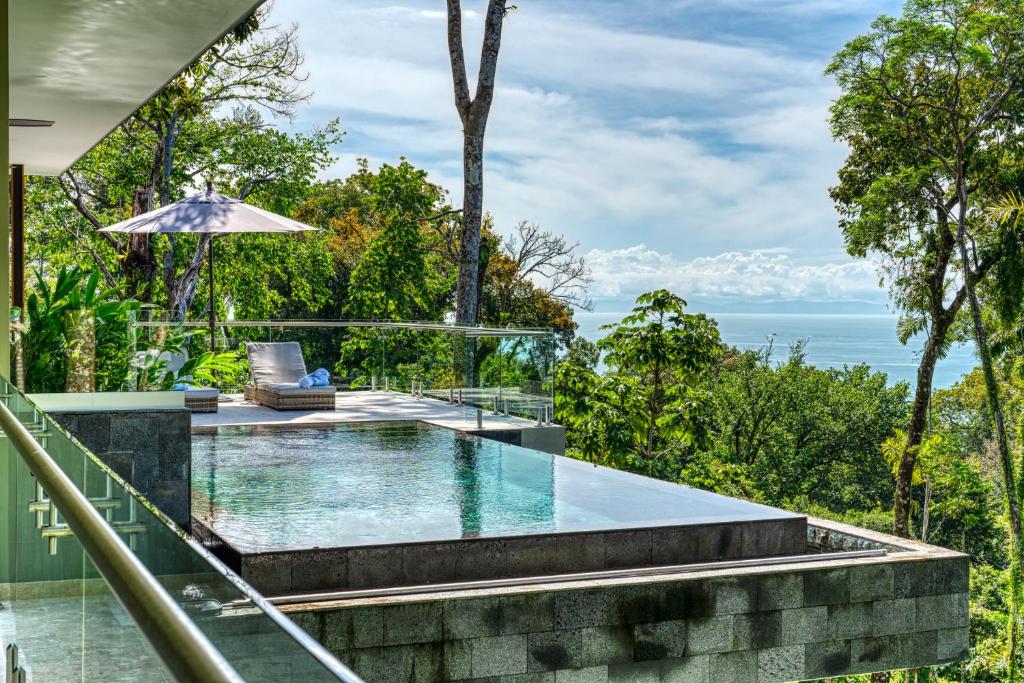 an infinity pool in a villa with a view of the ocean at Casa Heliconia in San Luis