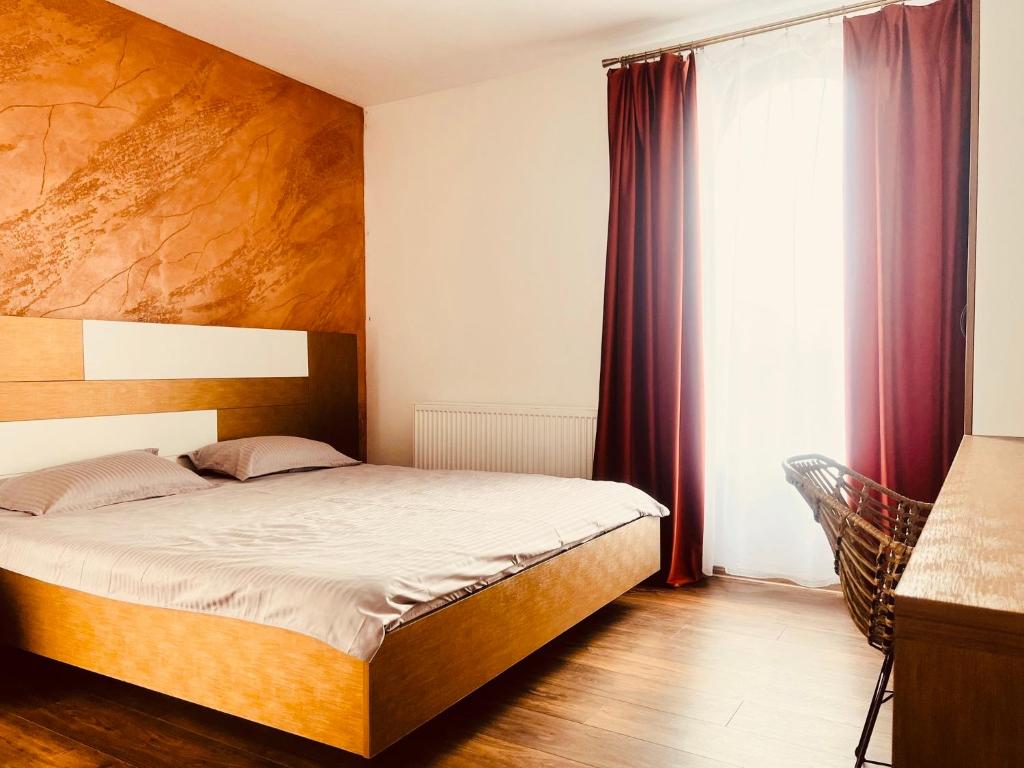 - une chambre avec un lit et une grande fenêtre dans l'établissement Green Garden, à Suceava