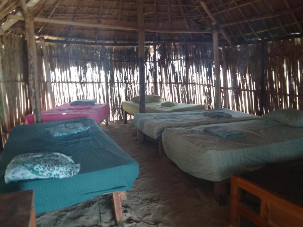 a group of four beds in a straw hut at Mares gunayarIslas in Nusatupo