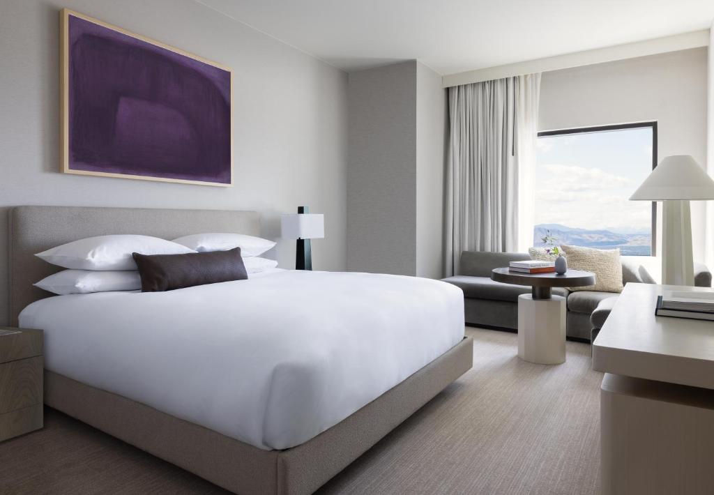 una camera con un grande letto bianco e un soggiorno di Kimpton Claret Hotel, an IHG Hotel a Denver