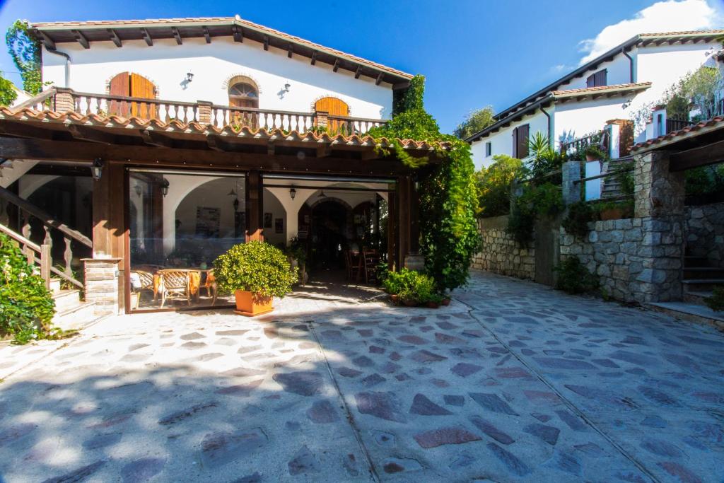 a large house with a balcony and a courtyard at Turismo Rurale La Miniera Fiorita in Arbus