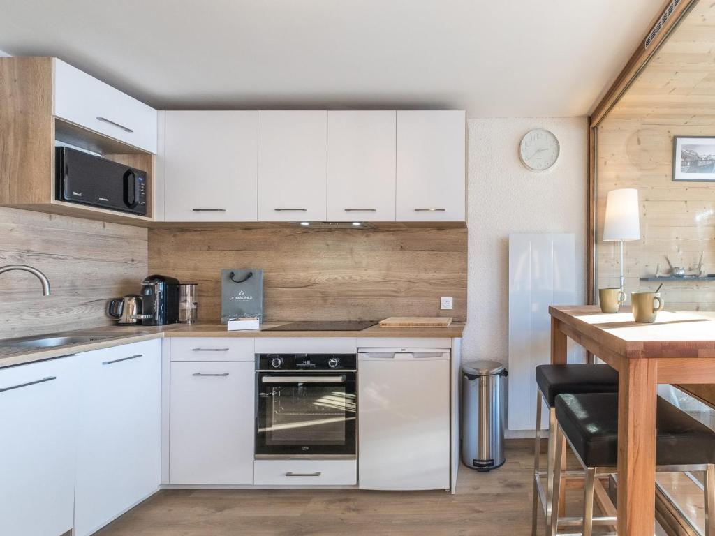 eine Küche mit weißen Schränken und einer Arbeitsplatte in der Unterkunft Appartement Val Thorens, 2 pièces, 6 personnes - FR-1-640-54 in Val Thorens