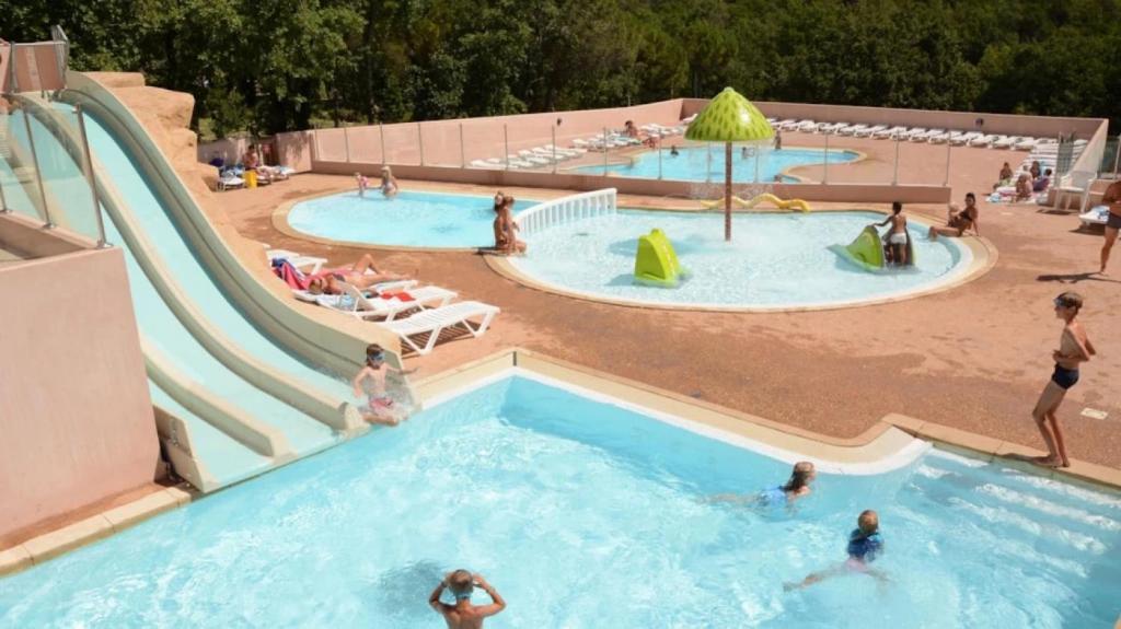 un grupo de personas en dos piscinas en un parque acuático en Mobilhome 3 étoiles - Parc aquatique - ef0fec en Saint-Paul-en-Forêt