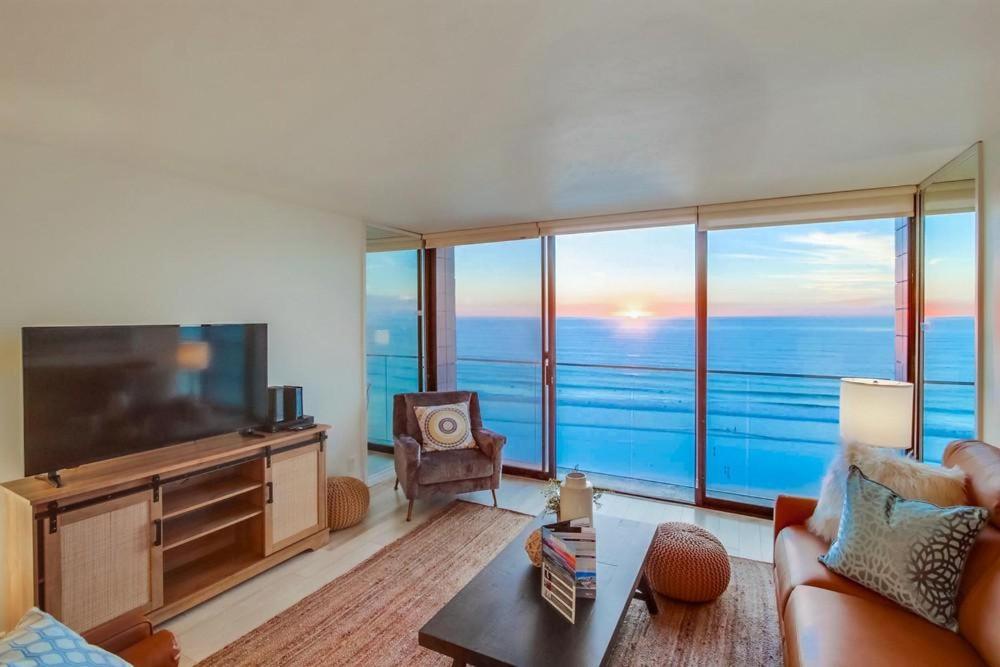 a living room with a large screen tv and a couch at Capri by the Sea in San Diego