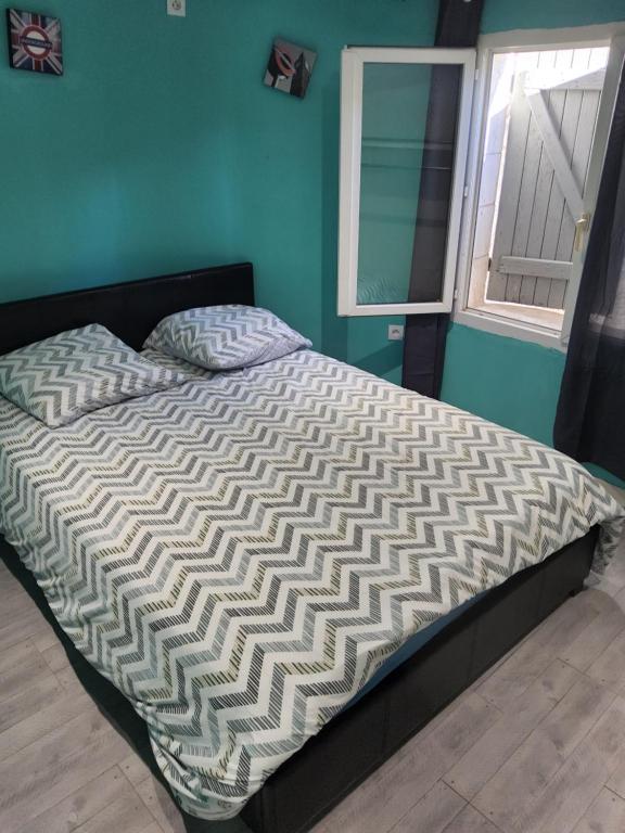 una cama en un dormitorio con ventana en Adorable appartement, en Pézenas