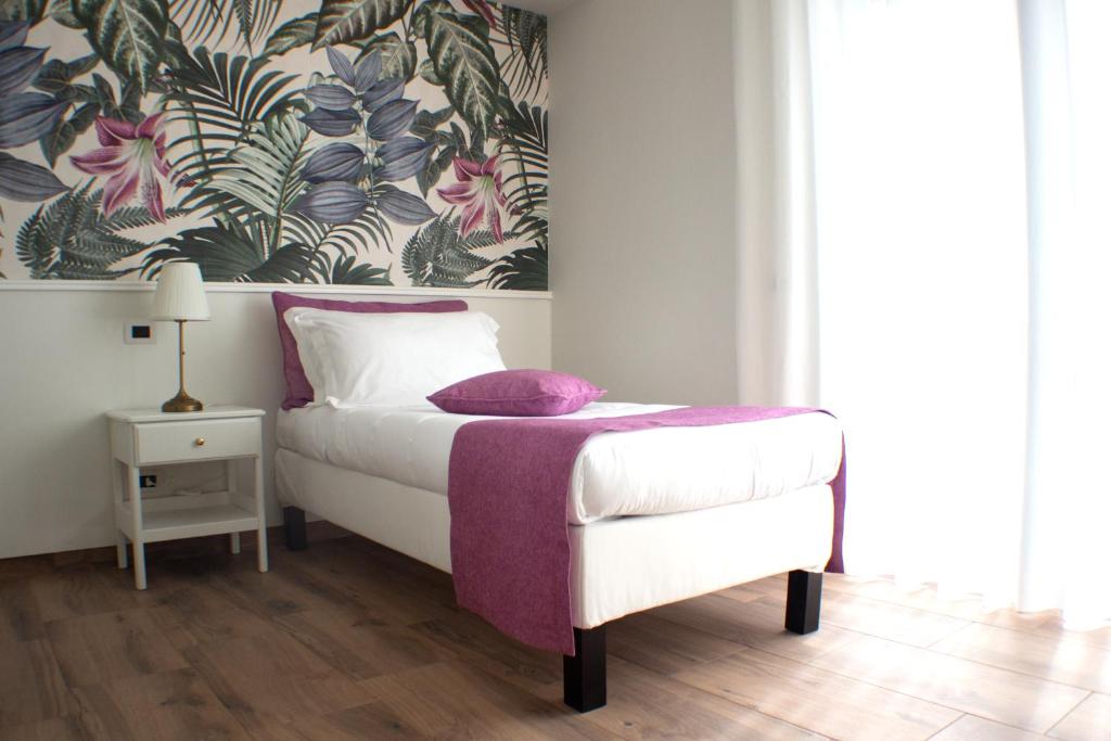 ein Schlafzimmer mit einem Bett mit einer lila Decke in der Unterkunft Il Piccolo Eden in Pontinia