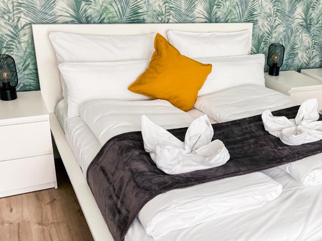 a bed with white sheets and yellow pillows at Gemütliches Apartment in zentraler Lage in Hamburg Alsterdorf für bis zu 7 Personen in Hamburg