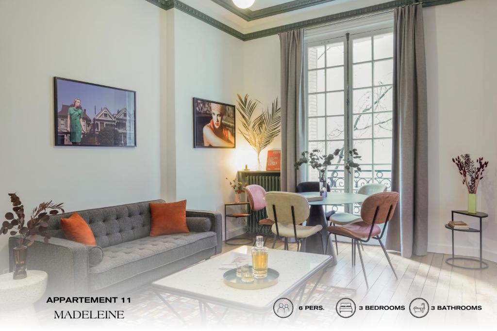 uma sala de estar com um sofá e uma mesa em Beauquartier - Madeleine em Paris