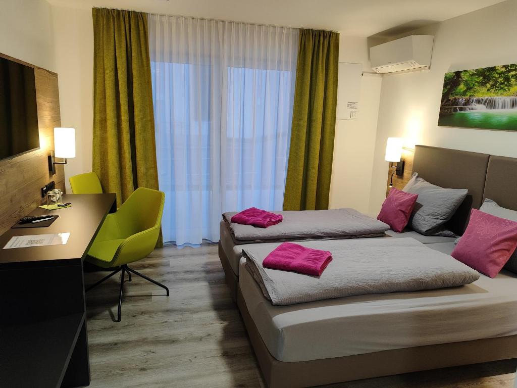 Cette chambre d'hôtel comprend 2 lits avec des oreillers roses. dans l'établissement Hotel Gästehaus Stock Zimmer Wasserfall, à Friedrichshafen