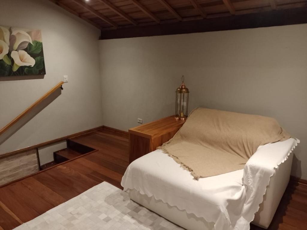 a room with a bed and a table in it at CHALÉS LUAR DO PICO in Santo Antônio do Pinhal