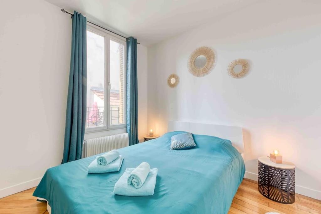 a bedroom with a blue bed and a window at Appartement cosy au calme, proche de Paris et du RER B in Gentilly
