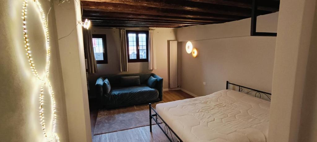 a small bedroom with a bed and a chair at Piccola Perla sul Canale in Venice