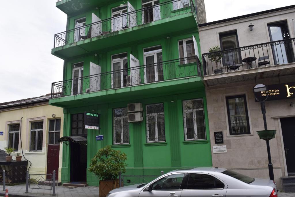 un edificio verde con un coche aparcado delante de él en Green Villa en Batumi