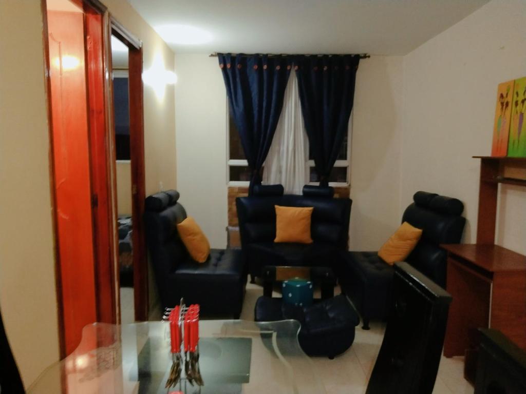 a living room with two chairs and a glass table at Apartamento a 20 minutos del aeropuerto in Bogotá