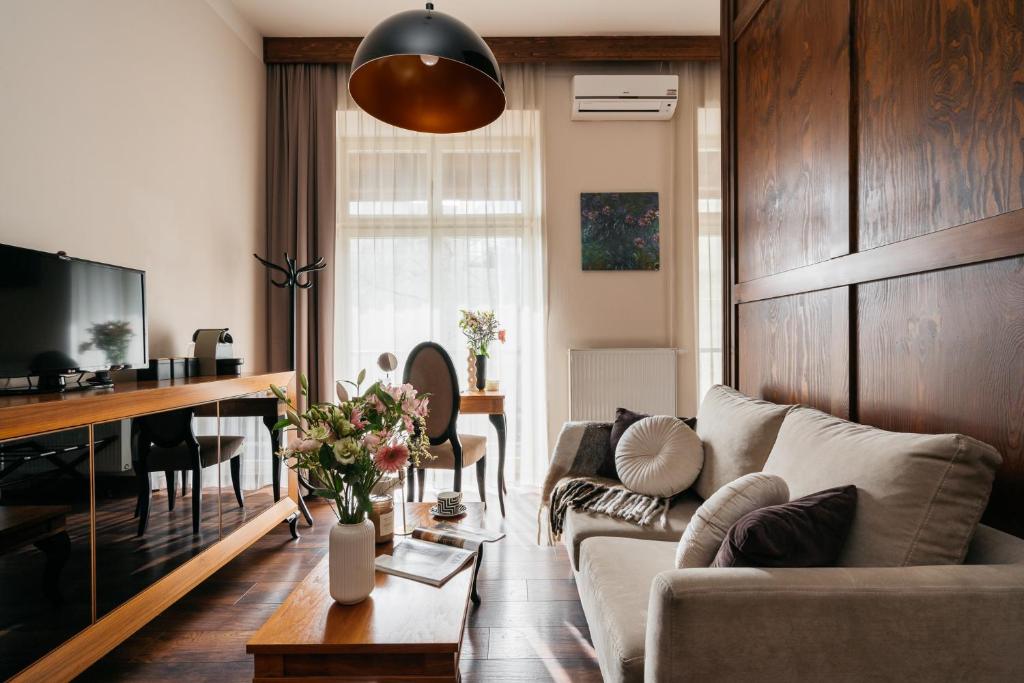 Topolowa Residence - LoftAffair Collection في كراكوف: غرفة معيشة مع أريكة وطاولة