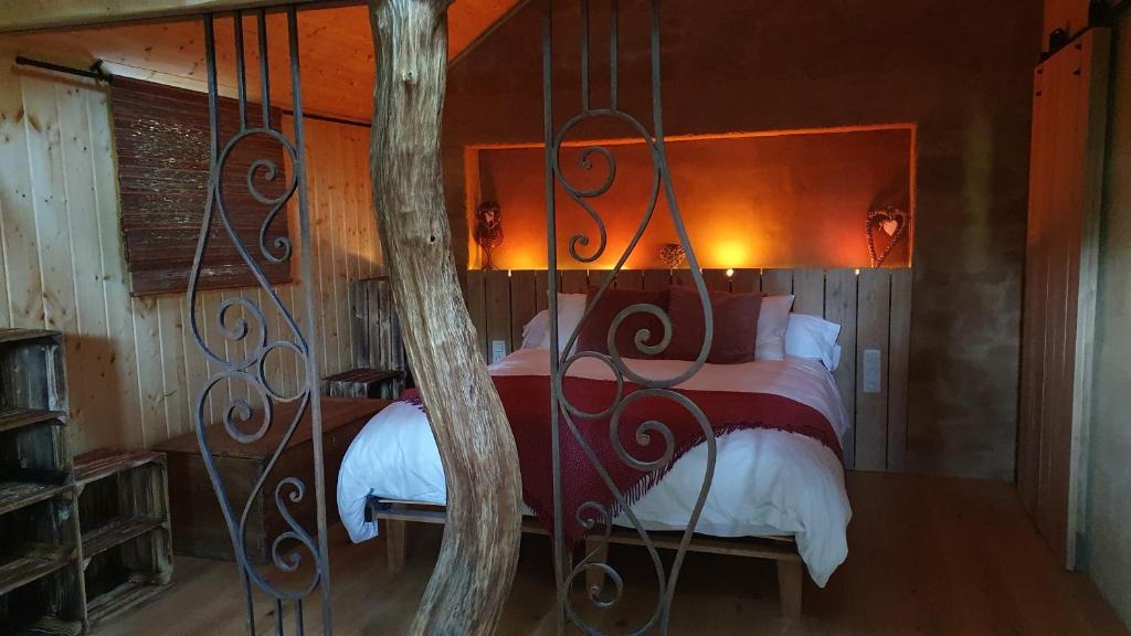 a bedroom with a bed with a tree in it at Gîte de Terre et de Charme in Hamoir