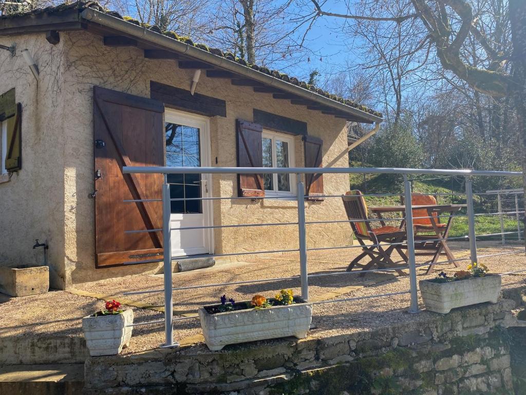 een klein huis met een veranda en een deur bij Domisiladore in Latouille-Lentillac