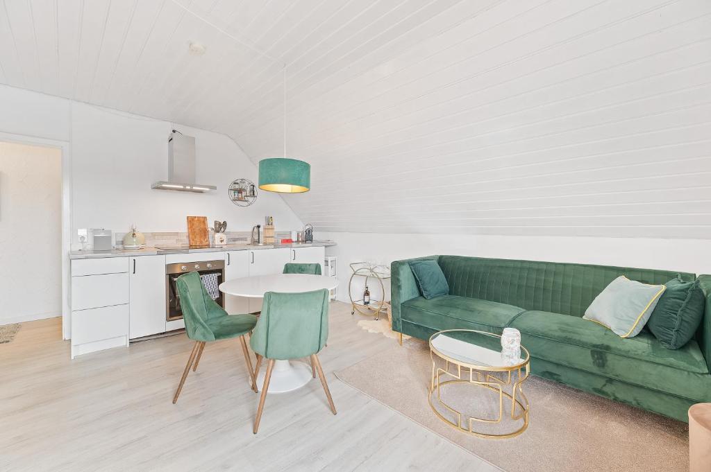 ein Wohnzimmer mit einer grünen Couch und einem Tisch in der Unterkunft Perouser Wohlfühloase in Rutesheim