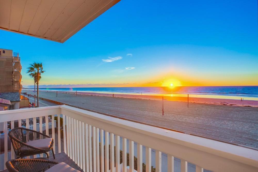 a balcony with a view of the beach at sunset at Rip Tide in San Diego