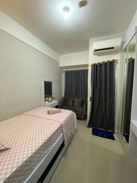 RawabugelにあるAPARTEMENT TRANSPAK JUANDA By Enjoy Roomのベッドルーム(ベッド1台、ソファ付)