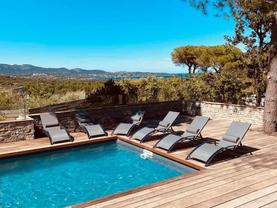- une piscine avec chaises longues sur une terrasse en bois dans l'établissement La Villa Cirindinu, à Cirendinu