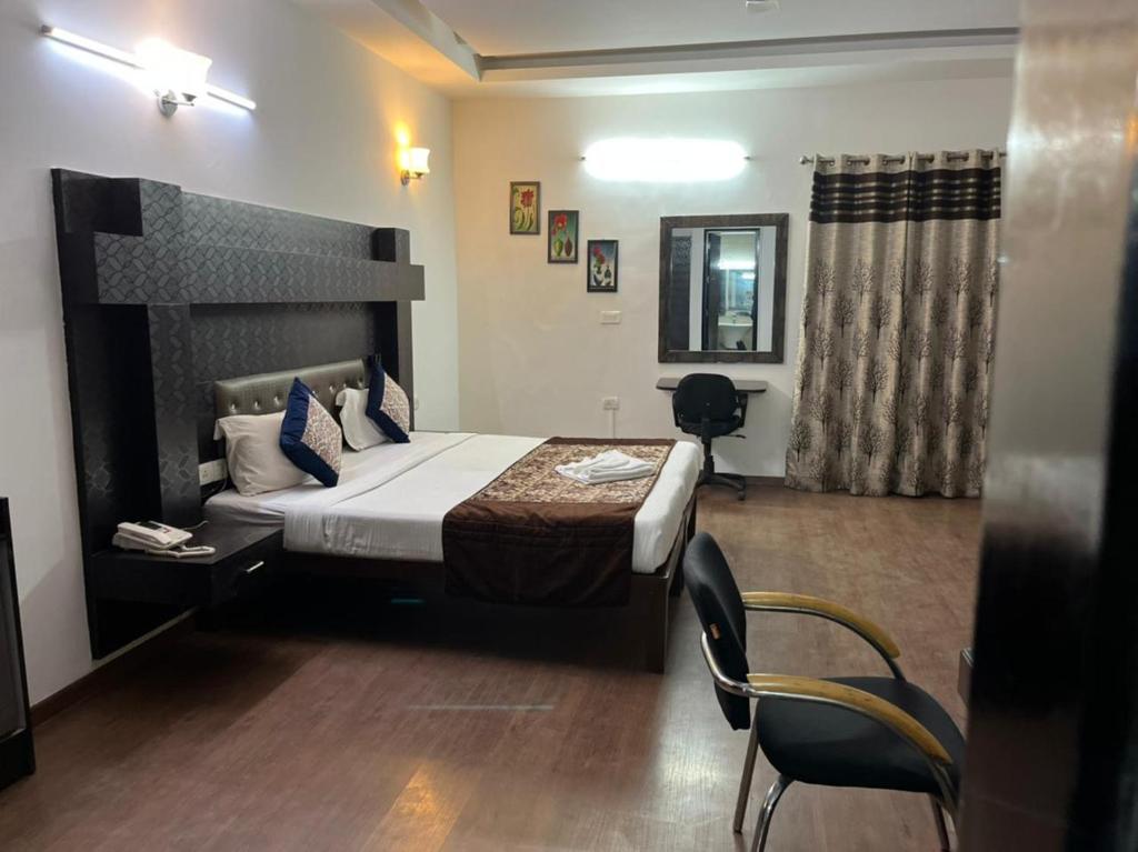 - une chambre avec un lit et des chaises dans l'établissement Staykr Rooms & BnB, à Gurgaon