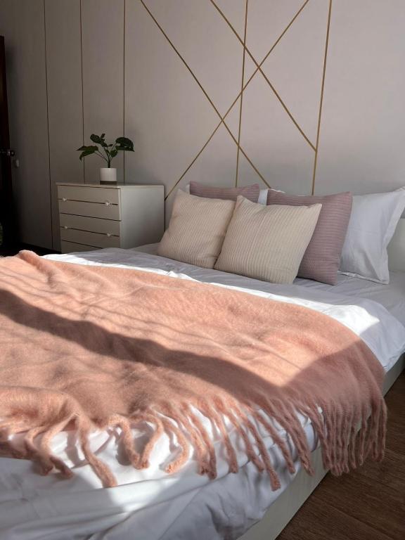 a bedroom with a large bed with a dog laying on it at Уютная двушка в центре in Temirtaū