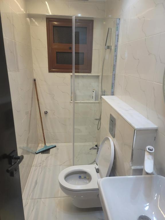 a bathroom with a toilet and a sink and a shower at Arizona luxury in Cairo