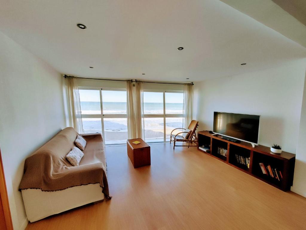 uma sala de estar com um sofá e uma televisão de ecrã plano em Breezy Beach Apartment em Sueca